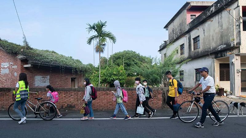 早晨7點，新光國小校長蘇清泉（右1）接學生到校，也是打開學校，跟社區連結的方式之一。圖片來源：黃明堂攝