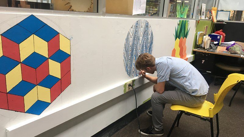 一位HTH的學生，正在繪製一幅以三角函數波型圖為美的數學壁畫作業。林竹芸攝