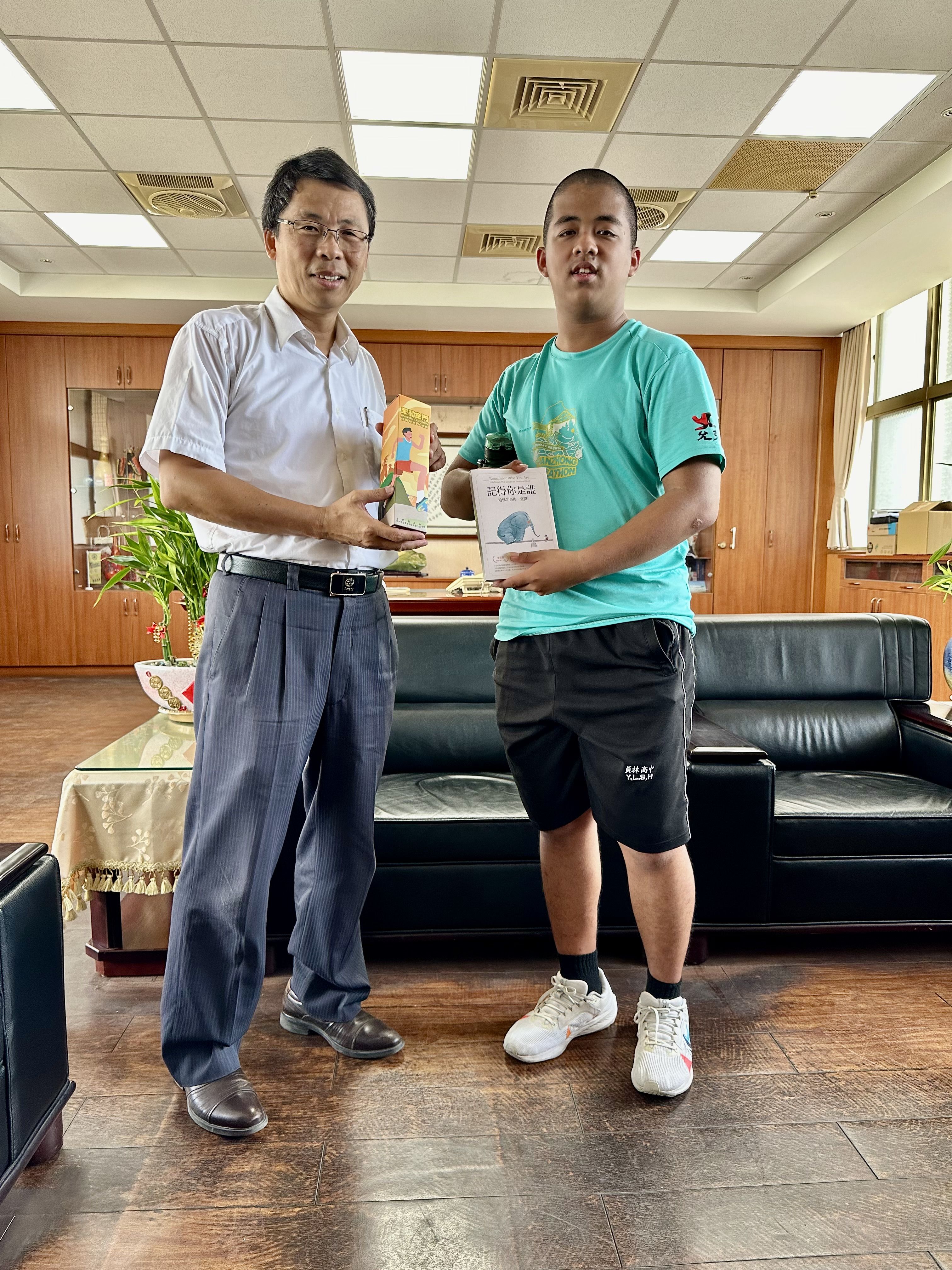 學生參加金門路跑,將參賽贈酒送楊豪森校長,校長回贈好書。