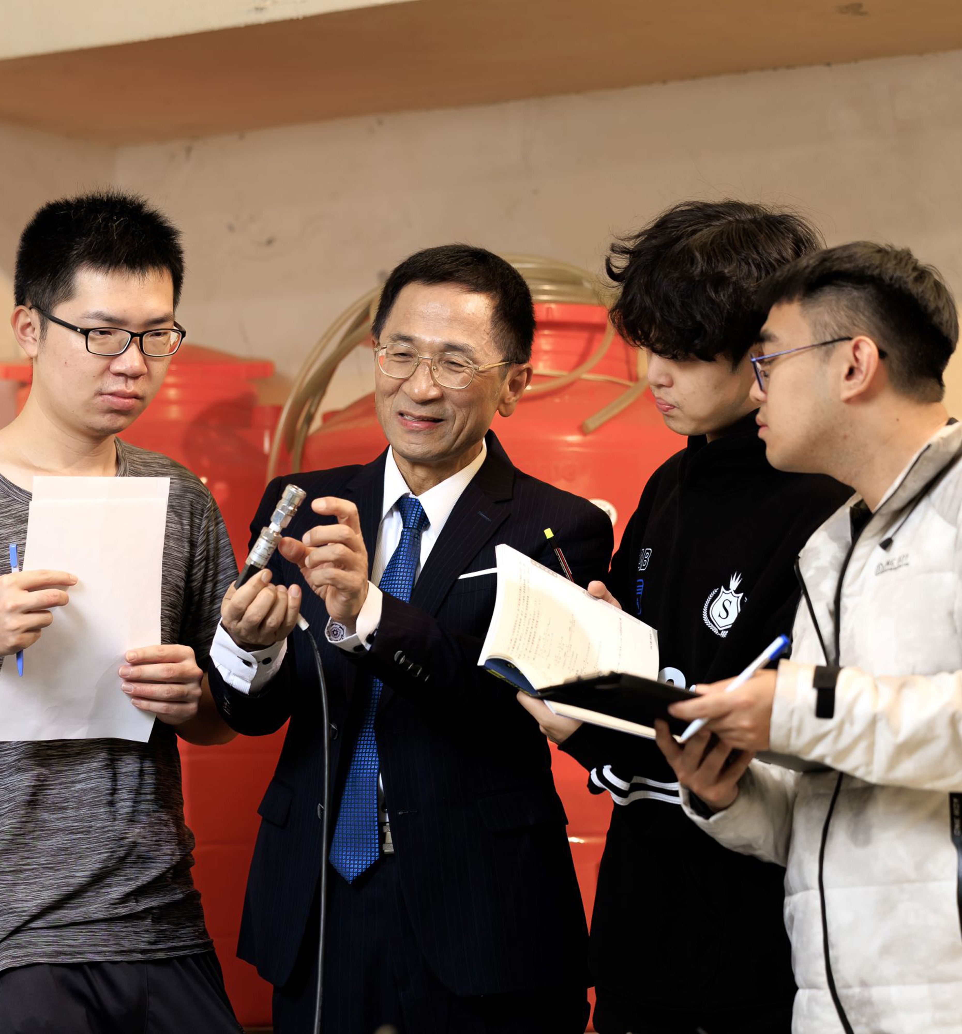 温志超（左二）耐心地與學生討論實驗細節，強調水利工程除了專業技術，更需要慢工出細活的細心。