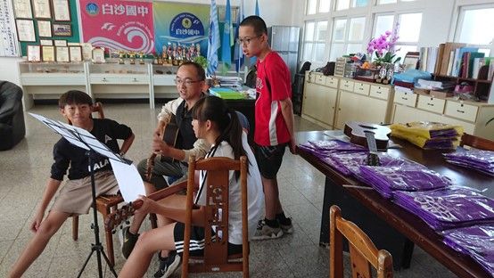 葉天文校長指導白沙國中學生彈唱吉他歌曲。