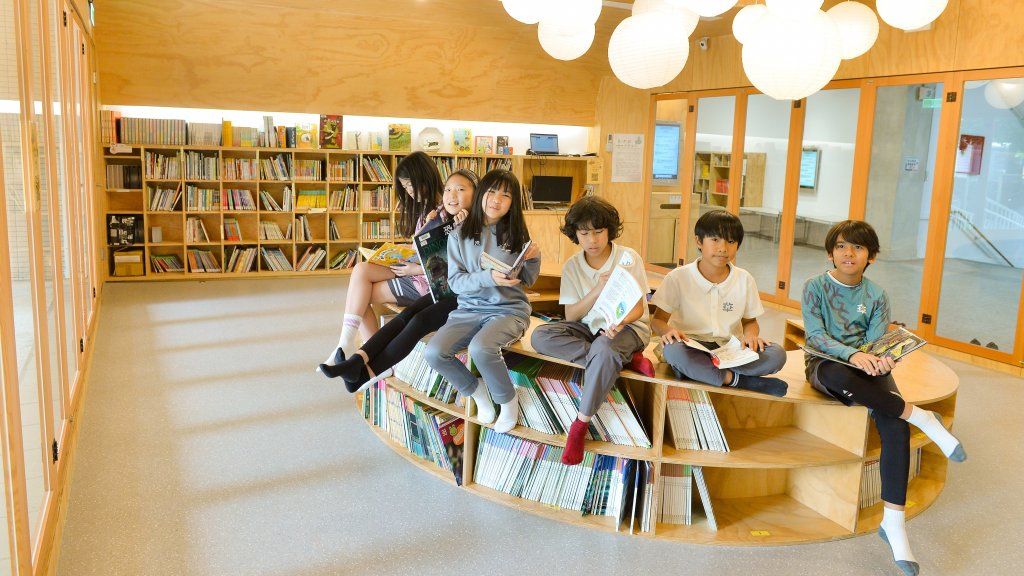 華砇圖書室，沒有固定高度的桌椅，用原木、圓型書櫃吸引孩子各種姿態的閱讀。黃建賓攝